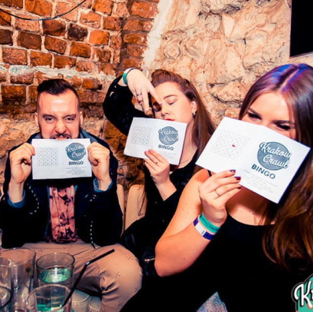 Pub crawlers playing one of the drinking games, drunk bingo, on a bar crawl in Krakow